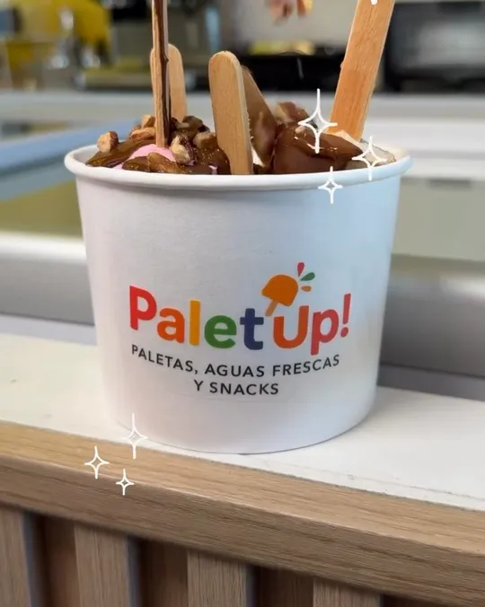 Toppings cayendo sobre un bowl de paletas con chocolate